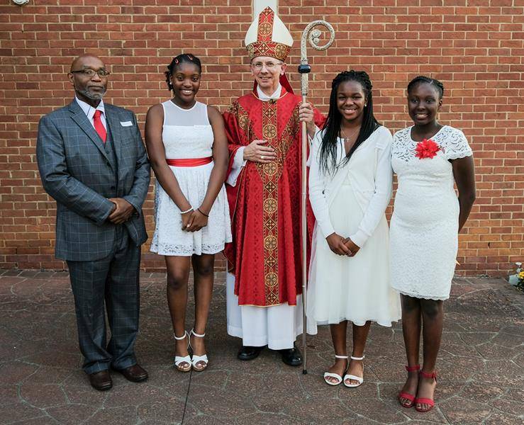 CHARLOTTE — (From left) John Young, Olivia Mukoko, Varleine Coq and Havilyn Smith of Our Lady of Consolation Parish received the sacrament of confirmation from Bishop Peter J. Jugis during Mass Sept. 22. (Travis Burton | Catholic News Herald)