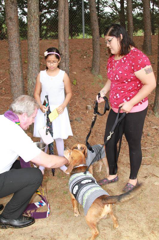 Father Paul Dechant, pastor, led a Blessing of Animals outside Holy Cross Church in Kernersville. Using a special bowl with holy water, he blessed parishioners’ pets, including Maximus and Odysseus, owned by Joanna Ruiz and her daughter Evelyn. (John Buny