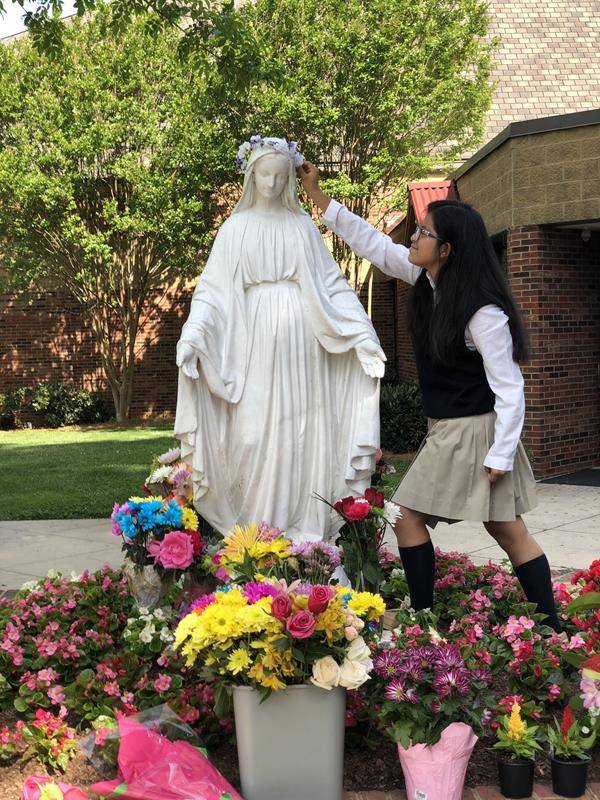 CHARLOTTE — Students at Our Lady of the Assumption School honor Mary for the month of May. Lupita Sanchez places a crown on the image of the Blessed Mother. (Photo provided by Allana-Rae Ramkissoon)