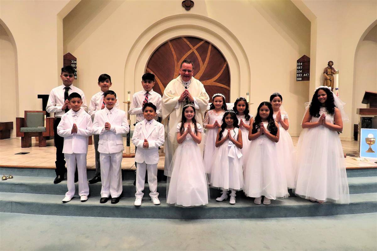 Father Thomas J. Kessler, pastor, celebrated the sacrament of First Holy Communion at St. Philip the Apostle Church in Statesville. Immediately after Mass the 14 recipients participated in the crowning of a statue of the Blessed Virgin Mary. The ceremony