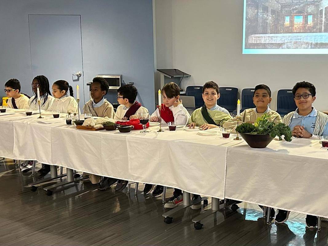 Students at Our Lady of the Assumption School gather for a Last Supper reenactment complete with a sacrificial lamb, bitter herbs and fresh greens.