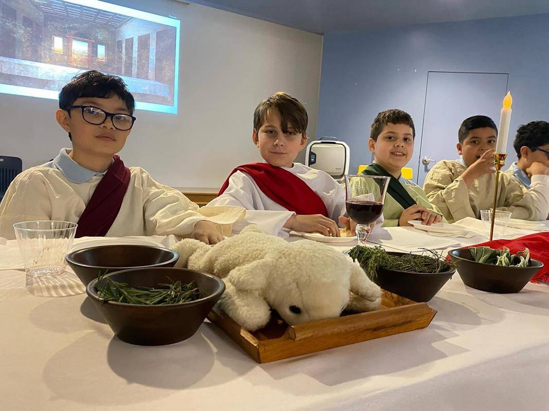 Students at Our Lady of the Assumption School gather for a Last Supper reenactment complete with a sacrificial lamb, bitter herbs and fresh greens.