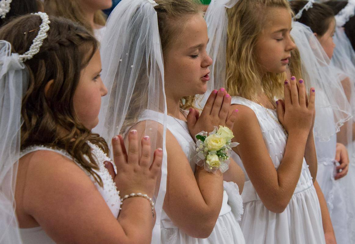 DENVER — Youth at Holy Spirit Church recently received the sacrament of first Holy Communion, during Masses offered May 6 by Father Carmen Malacari, pastor, and May 11 by Bishop Peter Jugis. (Photos by Doreen Sugierski | Catholic News Herald)