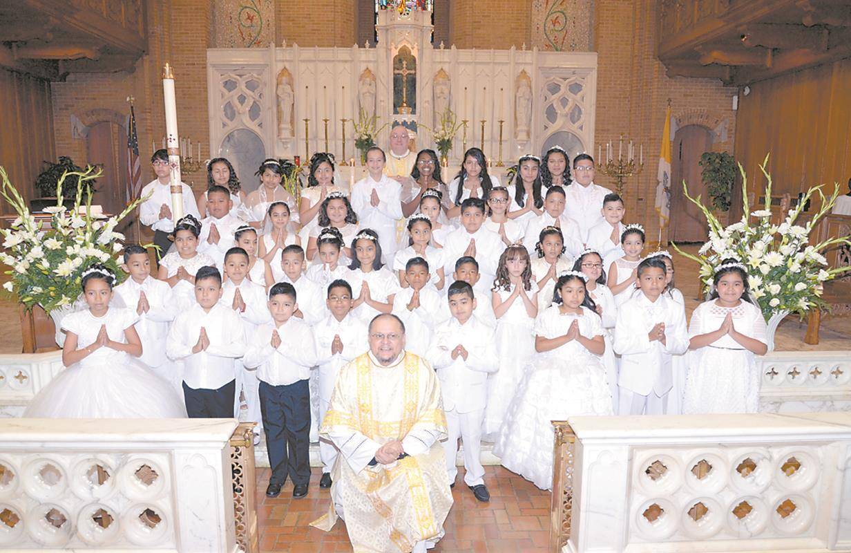 GREENSBORO — Two groups of Latino children at Our Lady of Grace Church received first Communion during Mass on June 3. They are pictured with Father Eric Kowalski, pastor, and Deacon Mark Mejías. — Photo provided by Deacon Mark Mejías