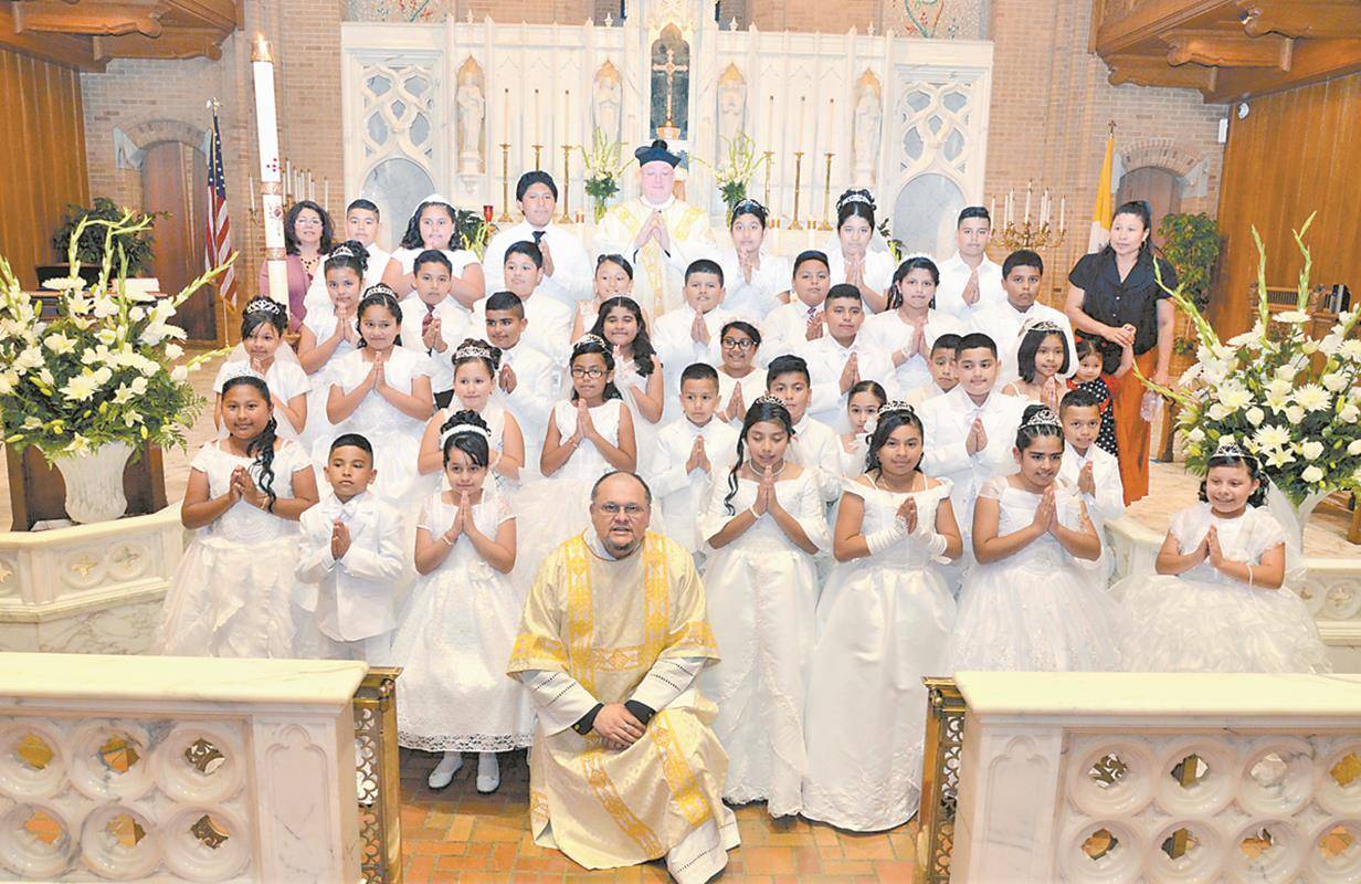 GREENSBORO — Two groups of Latino children at Our Lady of Grace Church received first Communion during Mass on June 3. They are pictured with Father Eric Kowalski, pastor, and Deacon Mark Mejías. — Photo provided by Deacon Mark Mejías