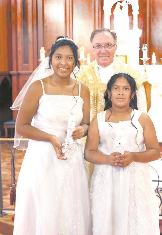 TRYON — Daisy Alviar and Perla Alviar received the sacrament of first Holy Communion on Trinity Sunday, June 11, at St. John the Baptist Church, during Mass celebrated by Father Roger Arnsparger, pastor. (Giuliana Polinari Riley | Catholic News Herald)