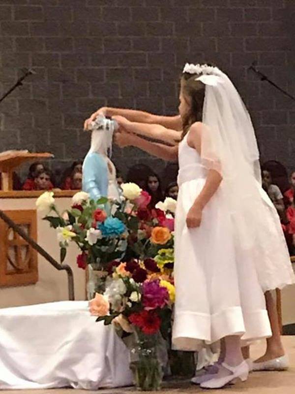 CHARLOTTE — Our Mother Mary was crowned by two of St. Matthew School’s second grade students who recently received their First Communion. (Photo via Facebook.)