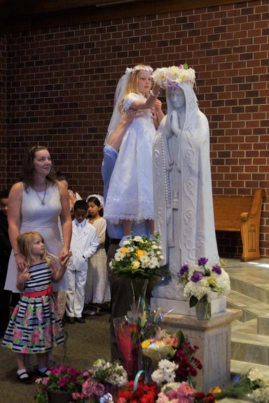 CHARLOTTE — Christina Kay crowned a statue of Mary May 7 at St. Thomas Aquinas Church. (John Cosmas | Catholic News Herald)