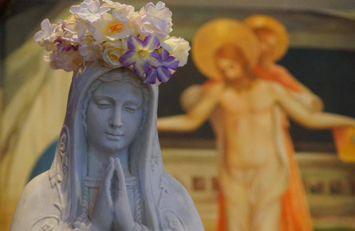CHARLOTTE — Christina Kay crowned a statue of Mary May 7 at St. Thomas Aquinas Church. (John Cosmas | Catholic News Herald)