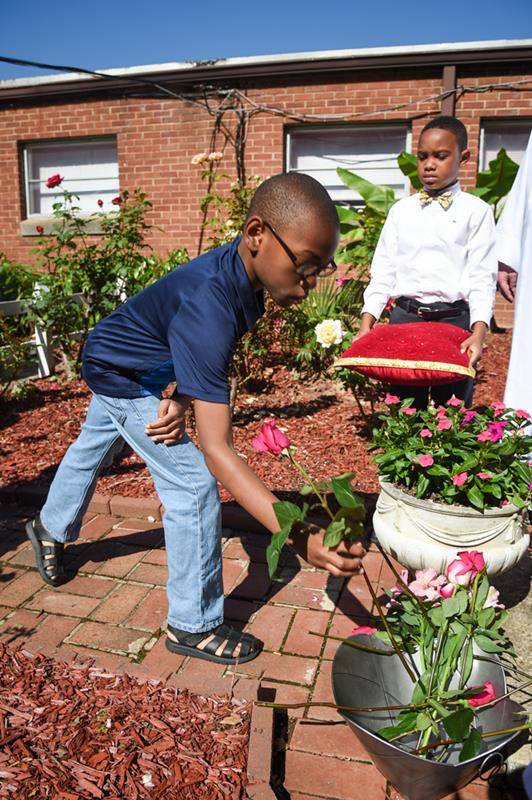 CHARLOTTE — Other parish youth at Our Lady of Consolation Church laid roses at the statue of Mary in the parish’s Marian garden. (Photos by Travis Burton | Catholic News Herald)